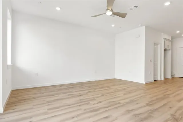 an empty room with wooden floor and hallway