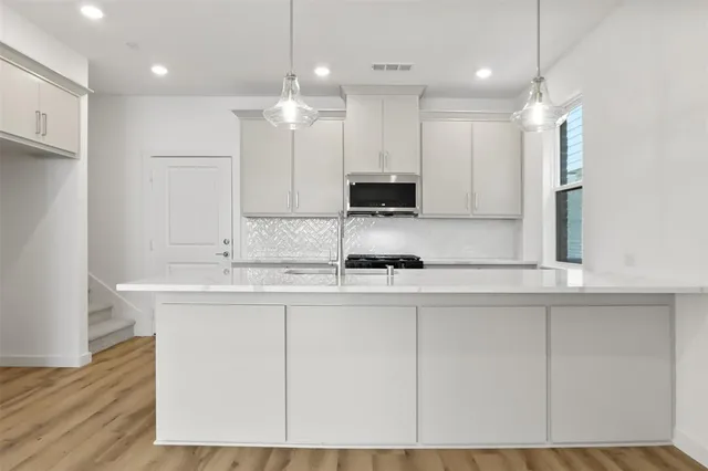 a kitchen with kitchen island white cabinets and sink