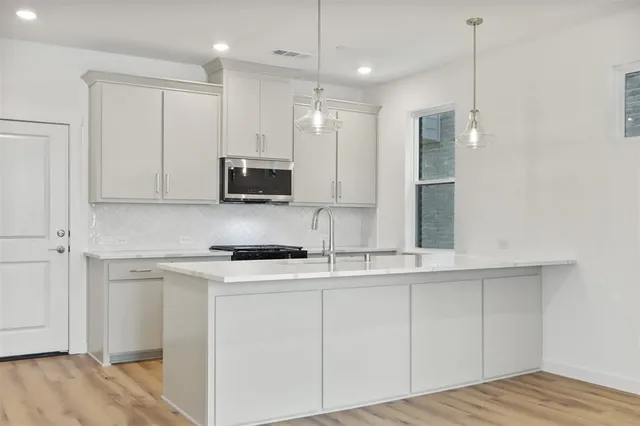a kitchen with kitchen island white cabinets stainless steel appliances and sink
