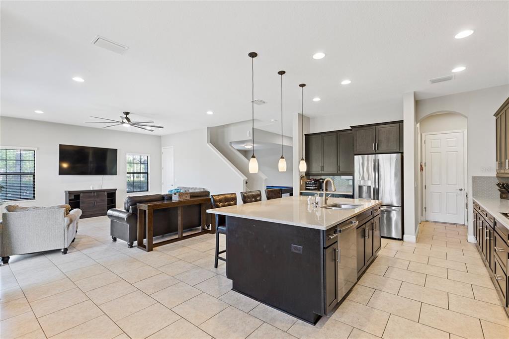 31976 Watoga Loop Wesley Chapel, FL 33543 - Photo 16 of 47 a kitchen with stainless steel appliances kitchen island granite countertop a sink and a refrigerator