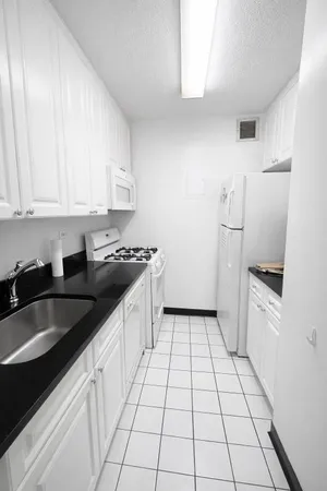 a kitchen with granite countertop a sink a stove and a refrigerator