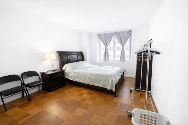 a bedroom with a bed chair and a large window