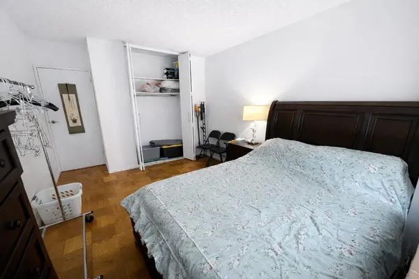 a bedroom with a bed and a flat tv screen on the dresser