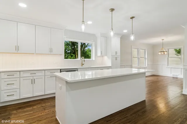 a kitchen with a sink stove and wooden floor
