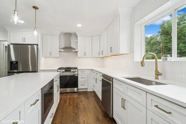 a kitchen with stainless steel appliances granite countertop a sink stove and refrigerator