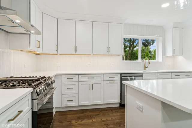 a kitchen with granite countertop a sink a stove and cabinets