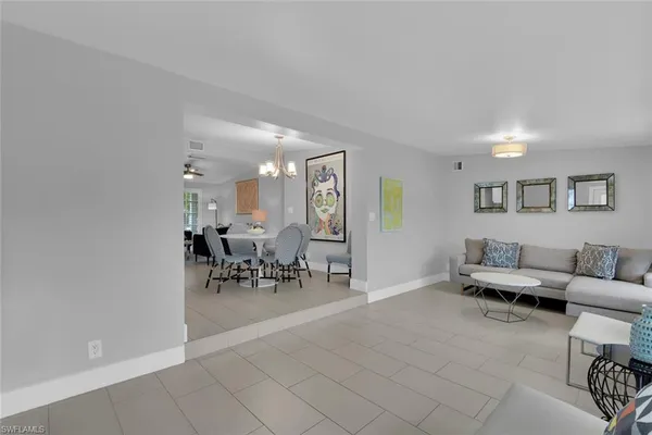 a living room with furniture and a dining table with potted plant