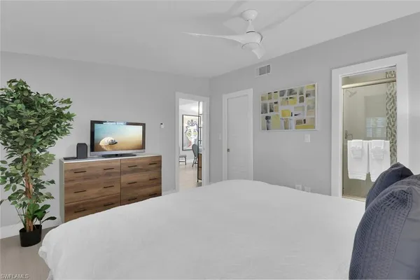 a bedroom with a bed potted plant and a dresser
