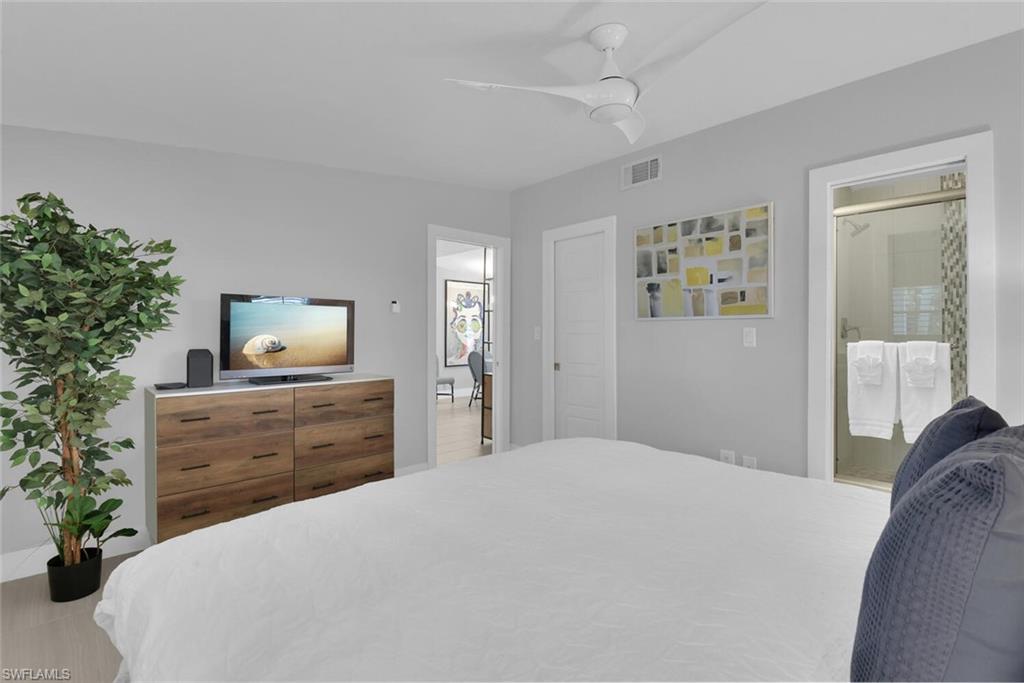 2048 Harbor Lane Naples, FL 34104 - Photo 15 of 35 a bedroom with a bed potted plant and a dresser