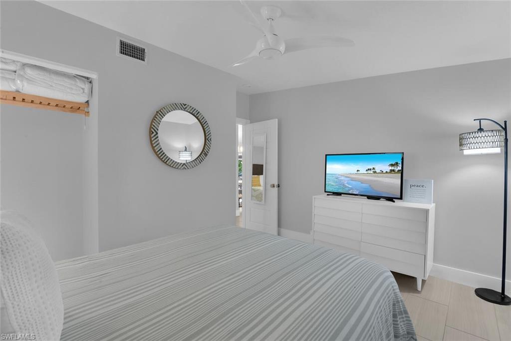 2048 Harbor Lane Naples, FL 34104 - Photo 19 of 35 a bedroom with a bed and a chandelier