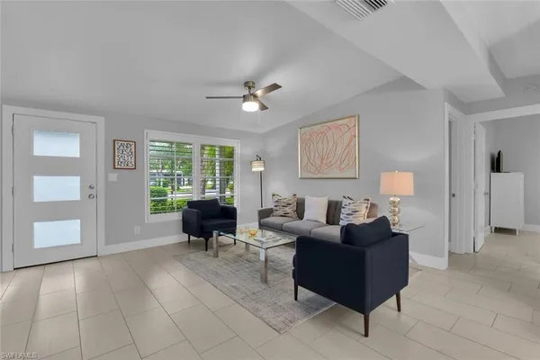 a living room with furniture and large windows