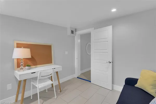 a view of a workspace with furniture and a window