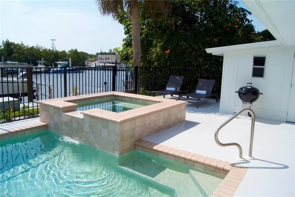 a view of a backyard with a tub and wooden fence