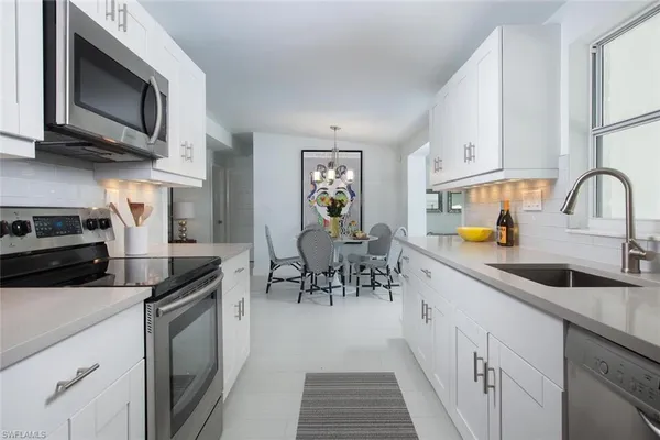a kitchen with stainless steel appliances a stove sink microwave and cabinets