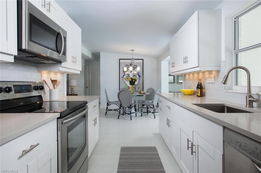 2048 Harbor Lane Naples, FL 34104 - Photo 5 of 35 a kitchen with stainless steel appliances a stove sink microwave and cabinets
