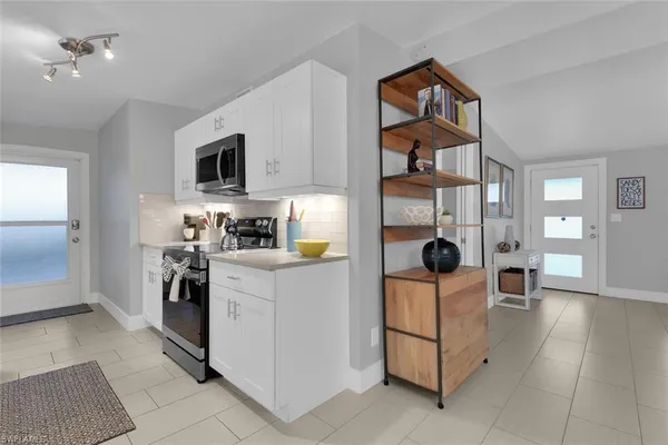 a kitchen with stainless steel appliances kitchen island granite countertop a refrigerator and microwave