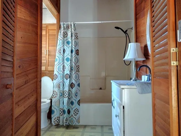 a bathroom with a shower curtain and a window