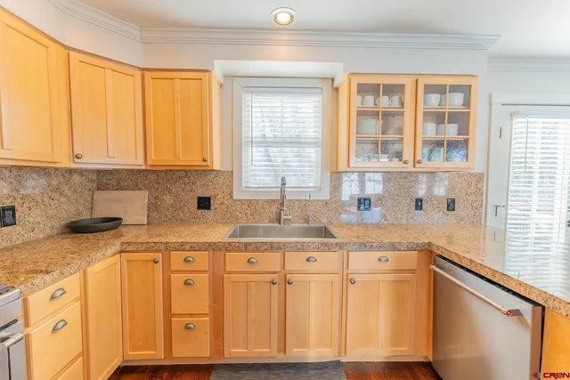 a kitchen with granite countertop cabinets stainless steel appliances a sink and a window