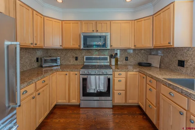 a kitchen with granite countertop white cabinets and stainless steel appliances
