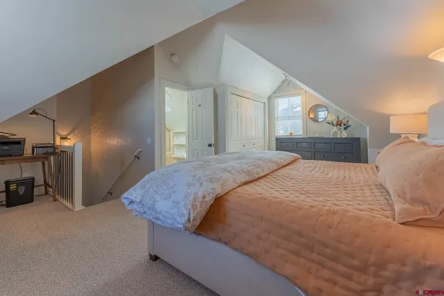 a spacious bedroom with a bed and a refrigerator