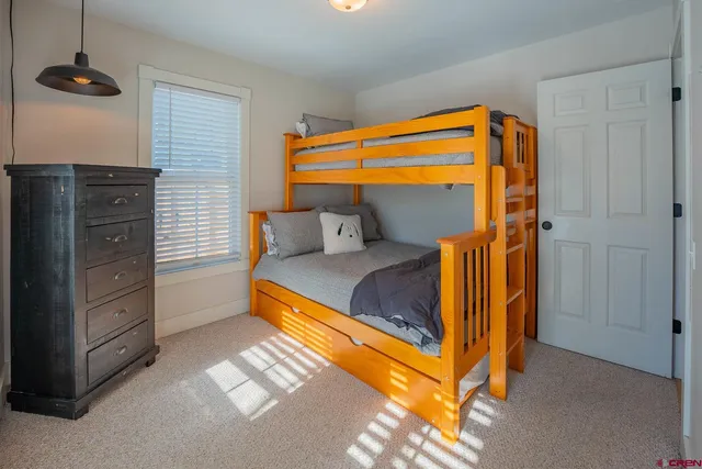 a bedroom with a bunk bed and a dresser