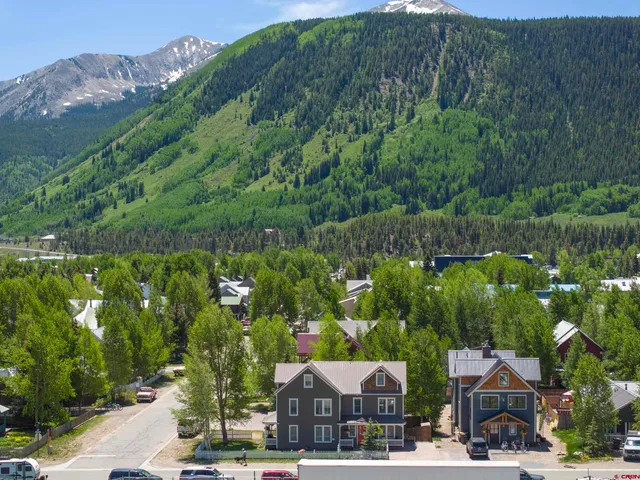 an aerial view of a house with a garden and lake view