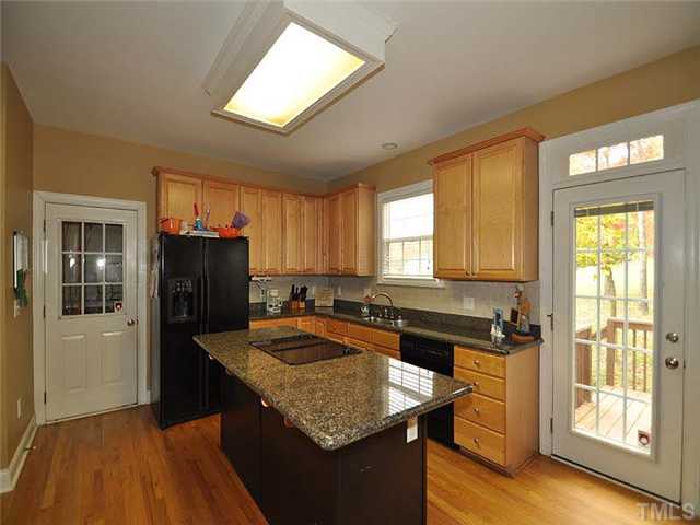 5325 Indigo Moon Way Raleigh, NC 27613 - Photo 6 of 13 The warm kitchen has granite counter tops, tile back splash, center island and adjoining breakfast nook.