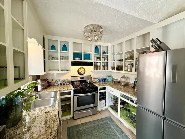 a kitchen with stainless steel appliances a stove a refrigerator and a stove