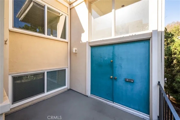 a view of a hallway with a white cabinet and chandelier