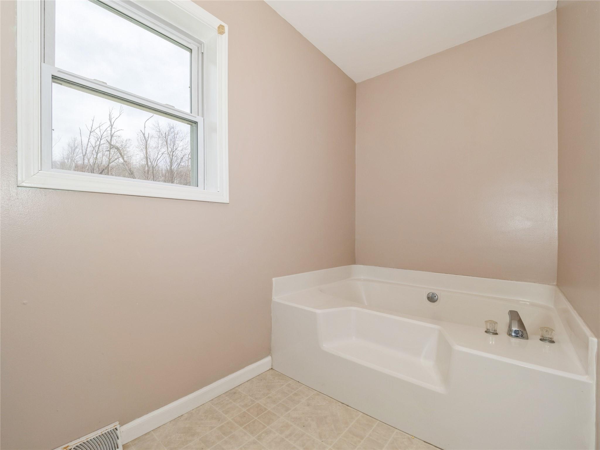 29 Dandelion Lane Wallkill, NY 12589 - Photo 13 of 50 a white bath tub sitting next to a small window
