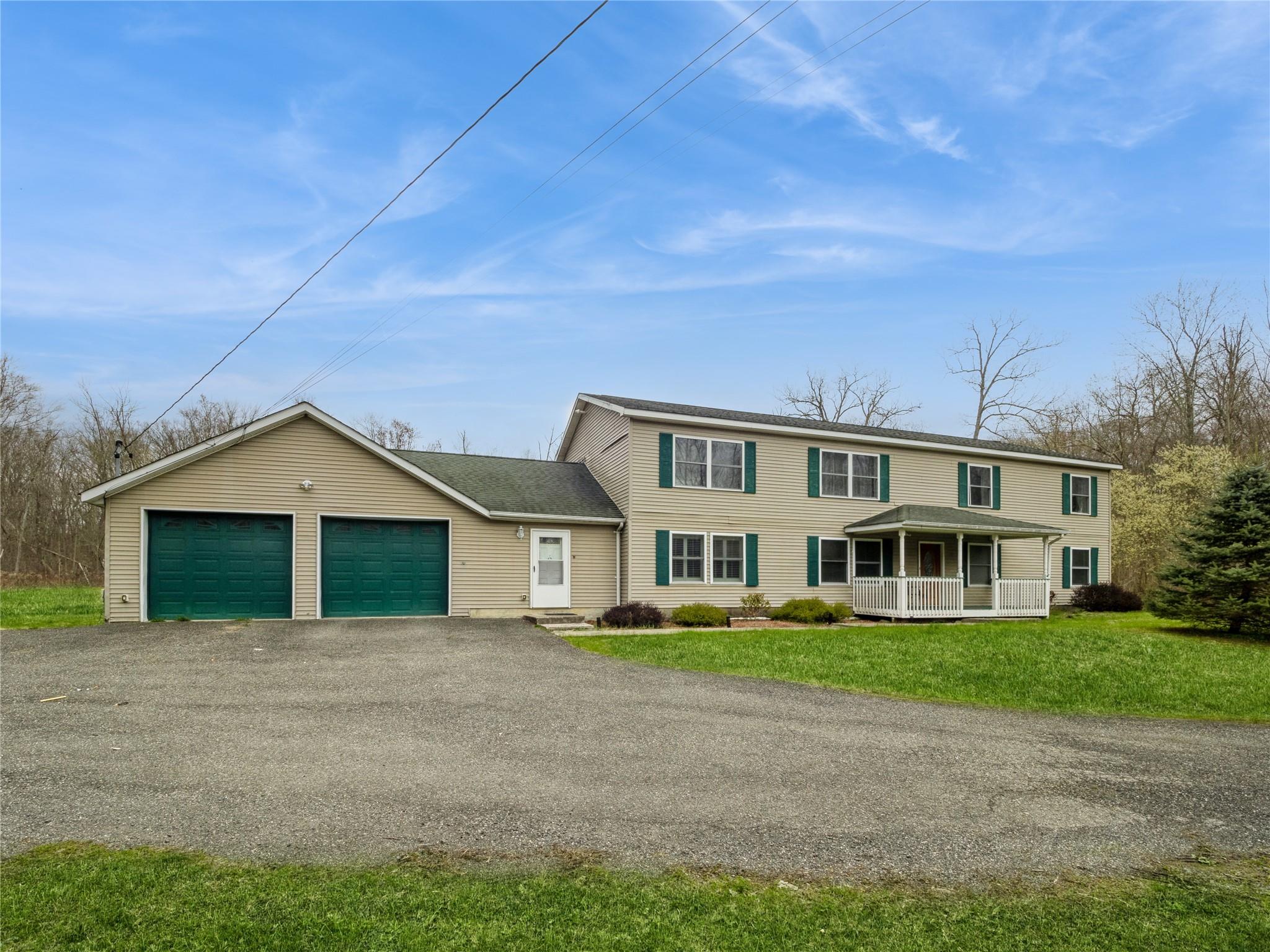 29 Dandelion Lane Wallkill, NY 12589 - Photo 3 of 50 a front view of a house with a garden and plants