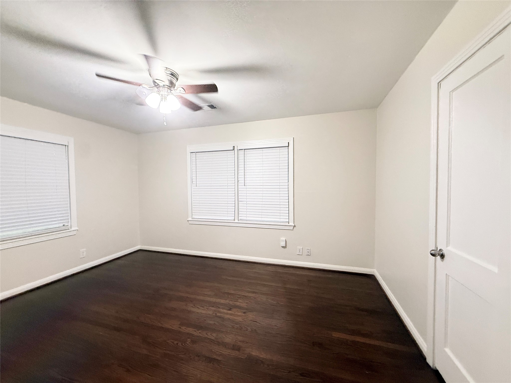1232 San Felipe Street Angleton, TX 77515 - Photo 8 of 16 an empty room with wooden floor fan and windows