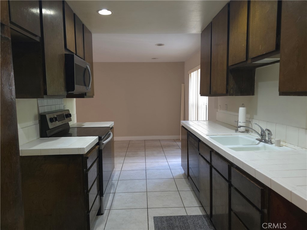 535 West Duarte Road, Unit 5 Arcadia, CA 91007 - Photo 2 of 17 a kitchen with a sink dishwasher a stove and a refrigerator with wooden cabinets