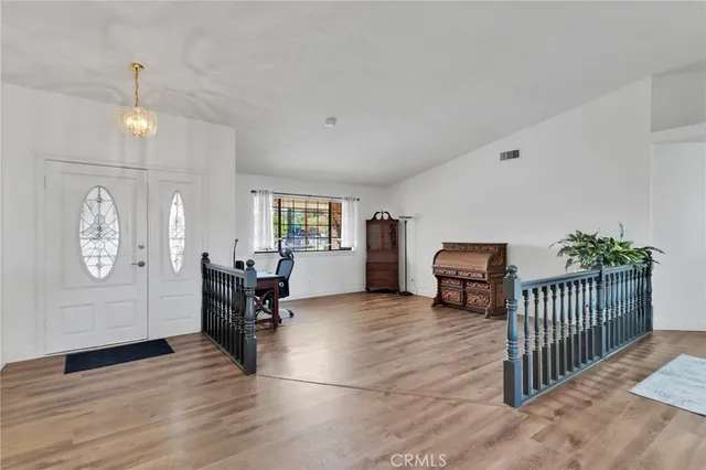 a view of a hallway with wooden floor and stairs