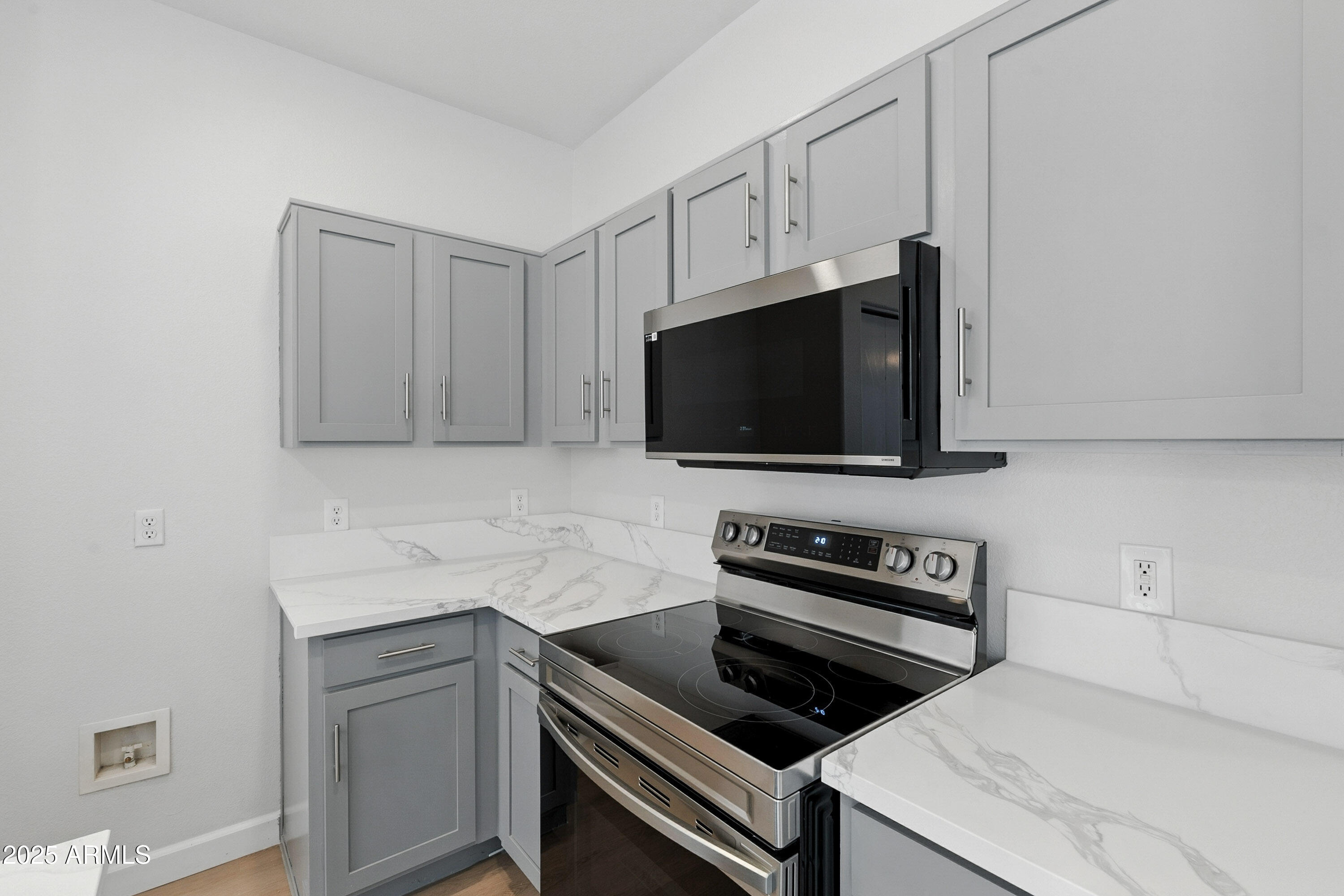 1409 East Bloch Road Phoenix, AZ 85040 - Photo 12 of 24 a kitchen with white cabinets and black appliances