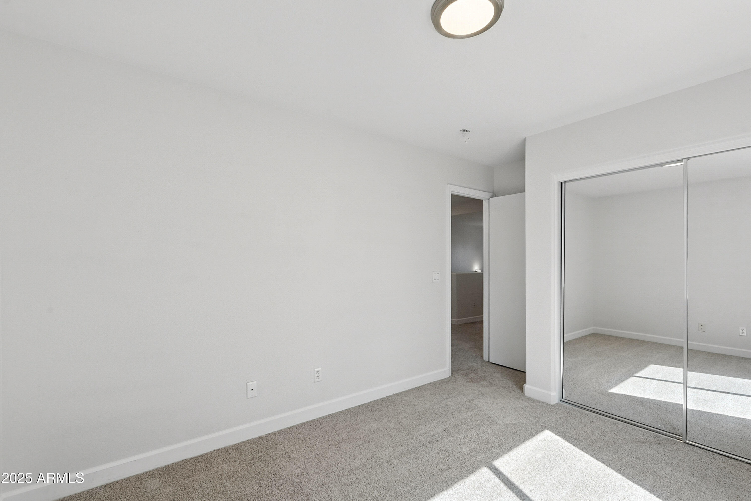 1409 East Bloch Road Phoenix, AZ 85040 - Photo 19 of 24 a view of an empty room with window and wooden floor