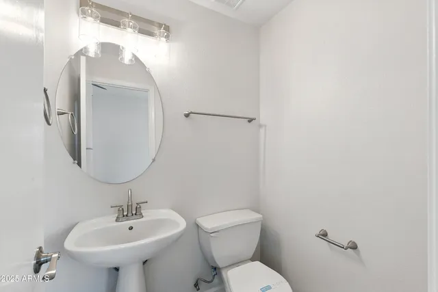 a bathroom with a sink toilet and a mirror
