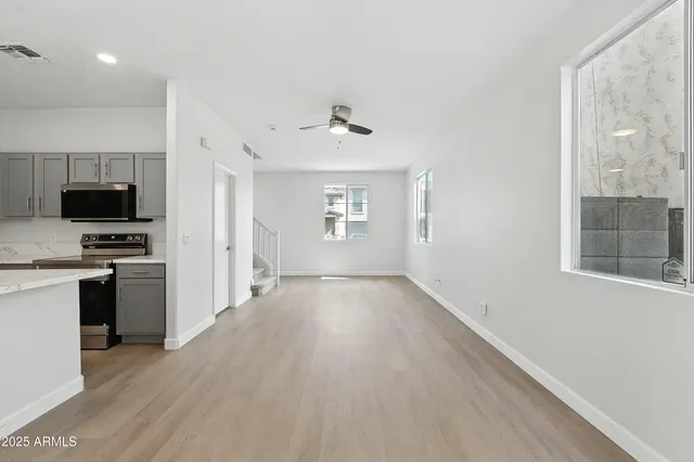 a view of a kitchen with a sink stove cabinets and empty room