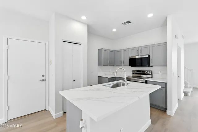 a kitchen that has a microwave a sink and a refrigerator