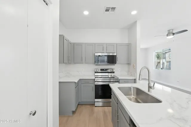 a kitchen with stainless steel appliances granite countertop a sink stove and refrigerator