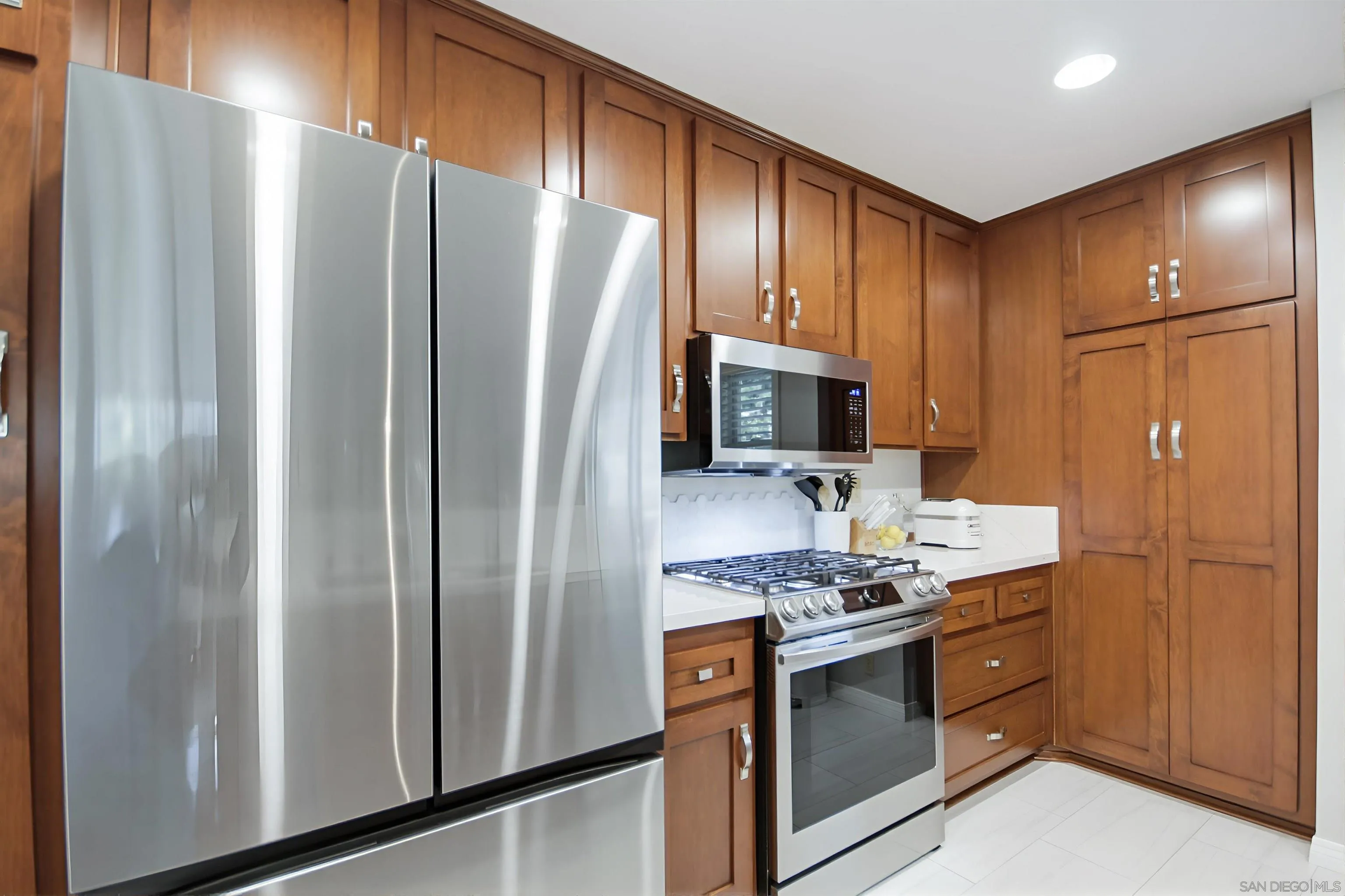 5822 Mission Center Road, Unit A San Diego, CA 92108 - Photo 13 of 35 a kitchen with stainless steel appliances granite countertop a refrigerator and a stove top oven