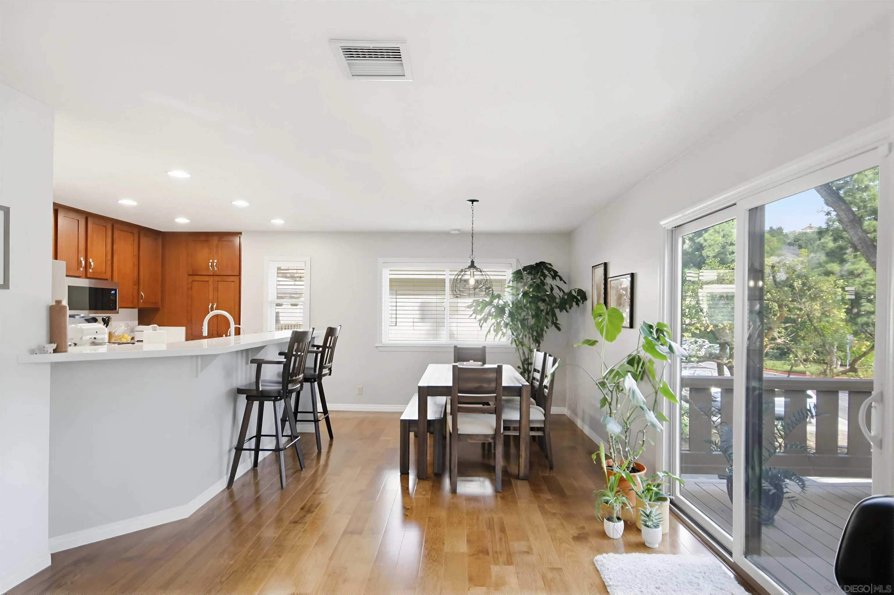 5822 Mission Center Road, Unit A San Diego, CA 92108 - Photo 6 of 35 a dining room with furniture potted plants and wooden floor