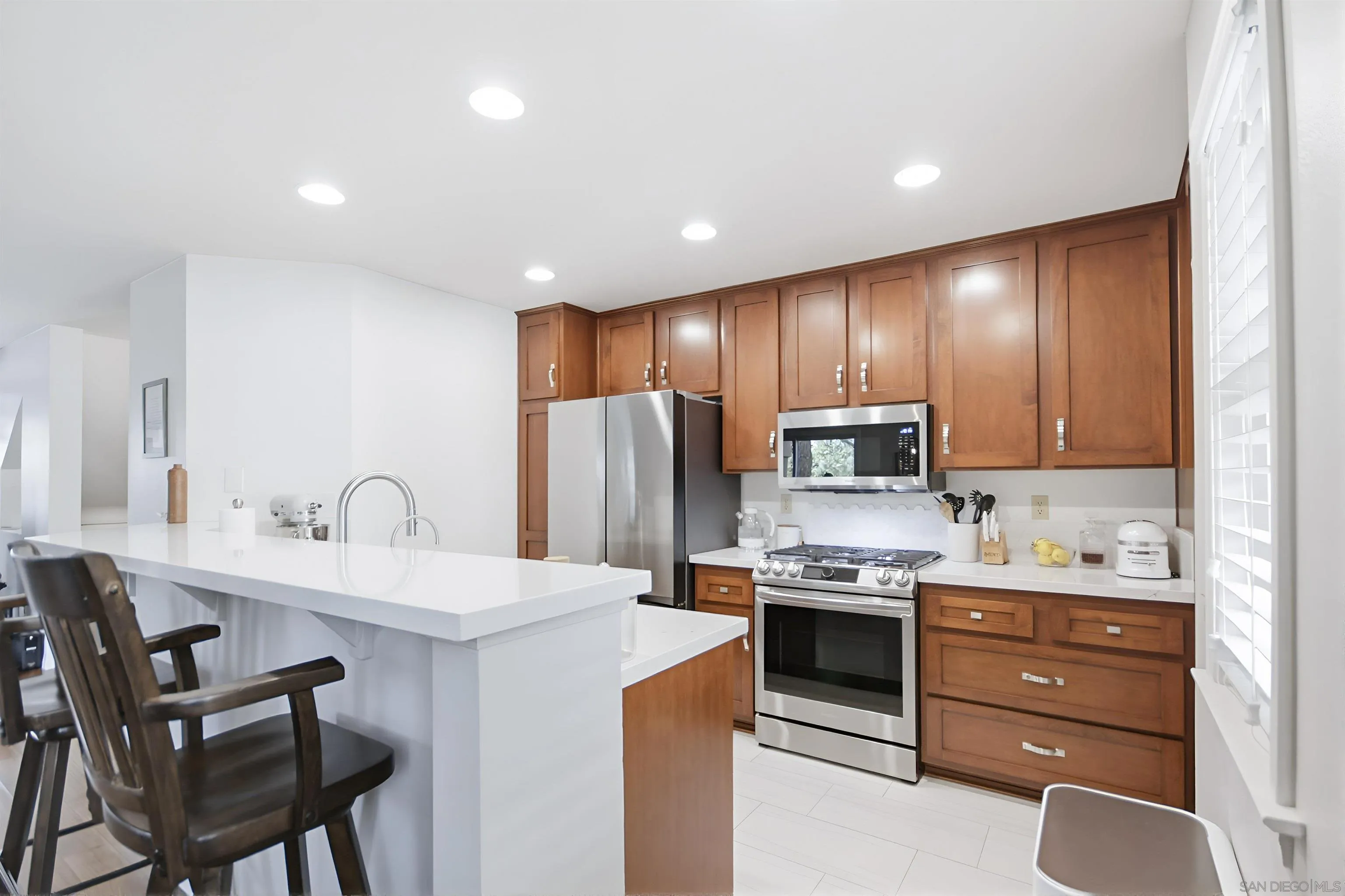 5822 Mission Center Road, Unit A San Diego, CA 92108 - Photo 9 of 35 a kitchen with stainless steel appliances kitchen island granite countertop a stove refrigerator and cabinets