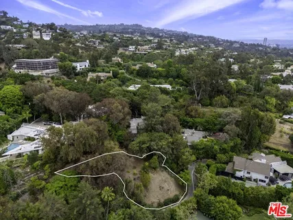 an aerial view of residential house with outdoor space and trees all around