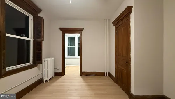 a view of a hallway with wooden floor and closet