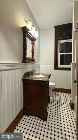 a bathroom with a granite countertop toilet sink and mirror