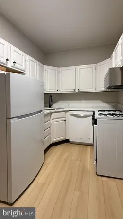 a kitchen with cabinets a counter top space stainless steel appliances and cabinets