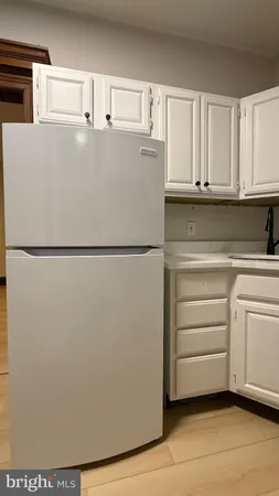 a white refrigerator freezer and a stove sitting inside of a kitchen