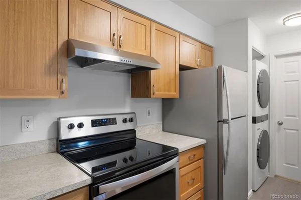 a kitchen with stainless steel appliances granite countertop a refrigerator and a stove
