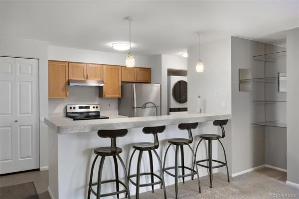 a kitchen with stainless steel appliances kitchen island granite countertop a dining table chairs and sink